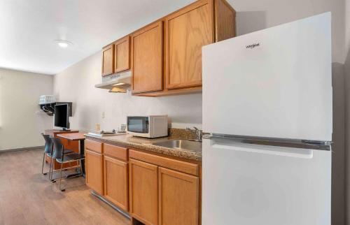 a kitchen with a white refrigerator and a sink at Extended Stay America Select Suites - Gulfport in Gulfport