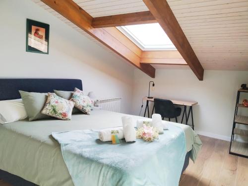 a bedroom with a bed with flowers and a skylight at el Atico de la Camara, centro Aviles, nuevo a estrenar in Avilés