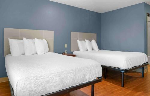 two beds in a room with blue walls at Extended Stay America Select Suites - Kalamazoo - West in Kalamazoo