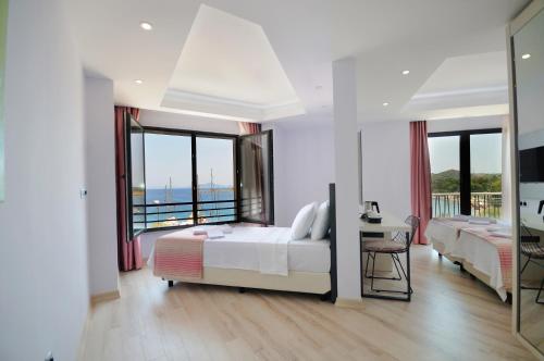a bedroom with two beds and a balcony at Datca Sapphire Hotel in Datca