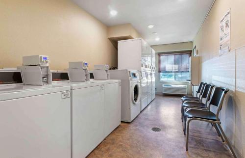 a laundry room with white appliances and chairs at Extended Stay America Select Suites - Kansas City - South - I-49 in Kansas City