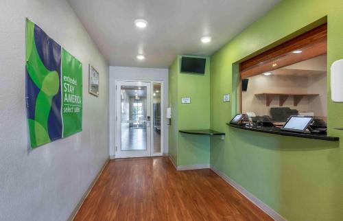 a room with green walls and a hallway with a desk at Extended Stay America Select Suites - Lake Worth in Lake Worth