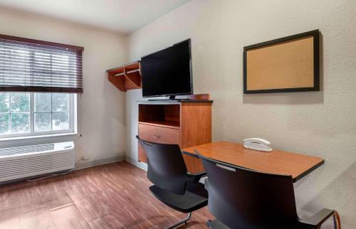 a room with a desk with a computer and a television at Extended Stay America Select Suites - Lake Worth in Lake Worth