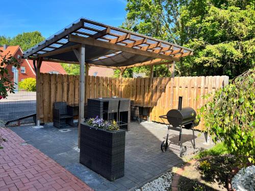 a patio with a grill and a wooden fence at Apartment Haus-Lisa Studio 1 in Emden