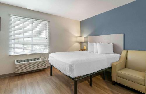 um quarto com uma cama, uma cadeira e uma janela em Extended Stay America Select Suites - Louisville - Airport em Louisville