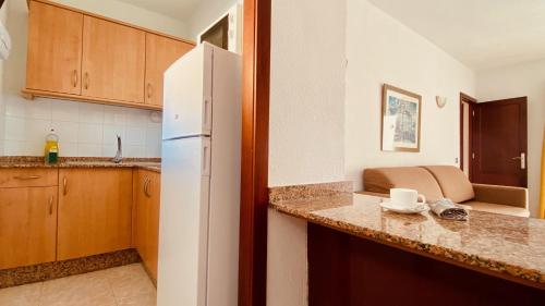 a kitchen with a white refrigerator in a room at Sunny apartment near the beach in Playa del Ingles
