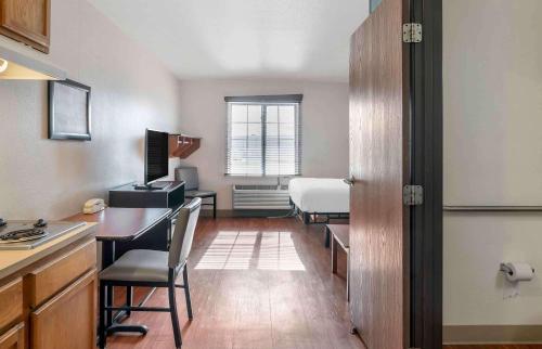 eine Küche mit einem Schreibtisch und ein Zimmer mit einem Bett in der Unterkunft Extended Stay America Select Suites - Louisville - South 