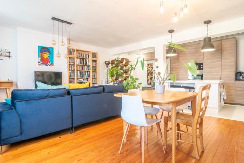 - un salon avec un canapé bleu et une table en bois dans l'établissement Escapade Culturelle Havraise, au Havre