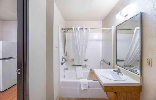 a white bathroom with a sink and a tub at Extended Stay America Select Suites - Lubbock - South in Lubbock
