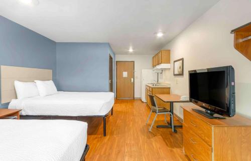 a hotel room with two beds and a television at Extended Stay America Select Suites - Charleston - North Charleston - I-526 in Charleston