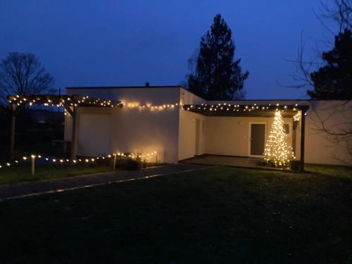 une maison avec un sapin de Noël et des lumières dessus dans l'établissement Gites au jardin, à Morsbronn-les-Bains