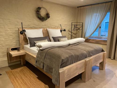 Un dormitorio con una gran cama de madera con almohadas en Lark One en Schleibnitz