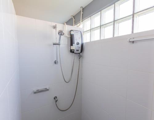 een douche in een badkamer met een telefoon aan de muur bij Chang Chang Hostel in Chiang Mai