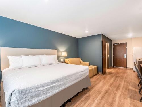a bedroom with a large bed and a chair at Extended Stay America Suites - Minneapolis - Airport - Mendota Heights in Mendota Heights