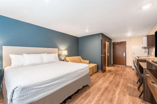 a hotel room with a bed and a kitchen at Extended Stay America Suites - Minneapolis - Airport - Mendota Heights in Mendota Heights