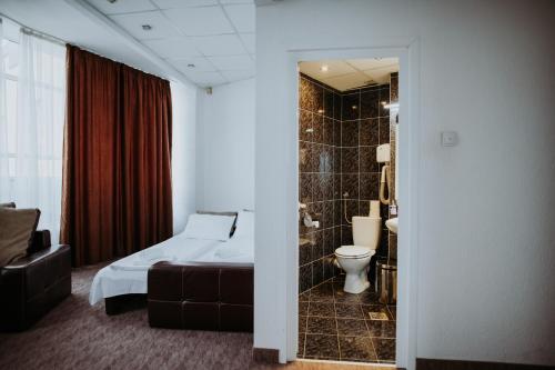 a hotel room with a bed and a toilet at Hotel Select in Sibiu
