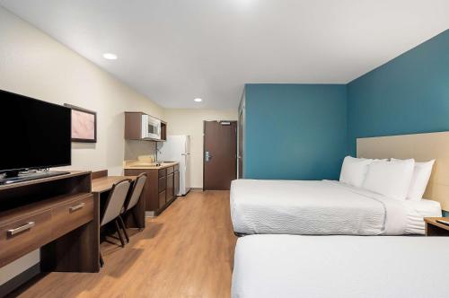 FridleyにあるExtended Stay America Suites - Minneapolis - Fridleyのベッド2台、薄型テレビが備わるホテルルームです。
