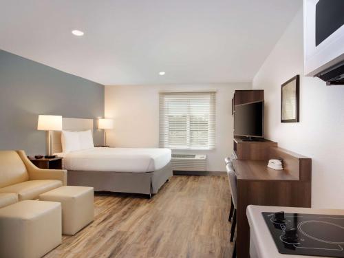 a hotel room with a bed and a couch at Extended Stay America Suites - Minneapolis - Fridley in Fridley