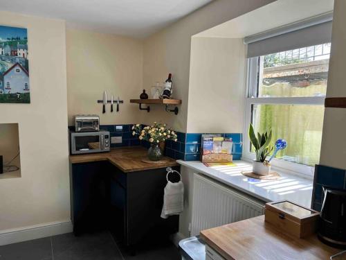 a kitchen with a counter top and a window at The Hive in St Austell