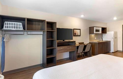 a room with a bed and a desk and a kitchen at Extended Stay America Suites - Norco in Norco