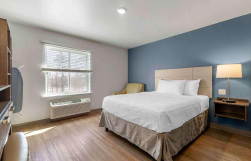 um quarto com uma cama grande e uma janela em Extended Stay America Suites - Nashua - Merrimack em Merrimack