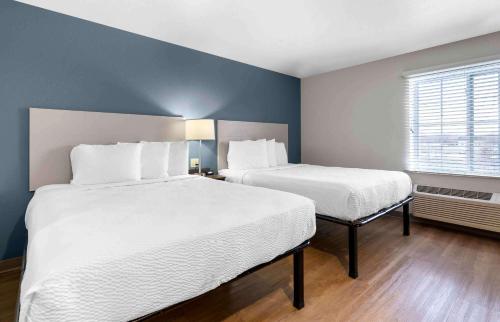 two beds in a small room with blue walls at Extended Stay America Suites - Nashua - Merrimack in Merrimack