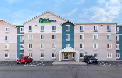 a large building with cars parked in a parking lot at Extended Stay America Select Suites - Fayetteville - Cliffdale in Fayetteville