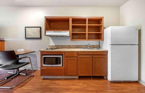 a kitchen with a white refrigerator and a sink at Extended Stay America Select Suites - Fayetteville - Cliffdale in Fayetteville