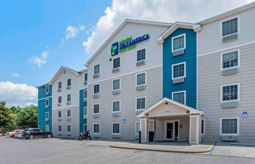 um grande hotel branco e azul com estacionamento em Extended Stay America Select Suites - Pensacola - Northeast em Pensacola