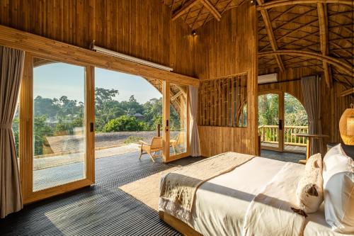 sypialnia z łóżkiem i dużym oknem w obiekcie Jungleight Bali w mieście Tegalalang