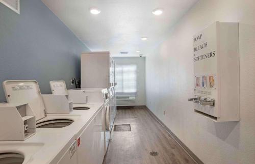 a laundry room with white counters and white appliances at Extended Stay America Select Suites - Panama City - Callaway in Callaway
