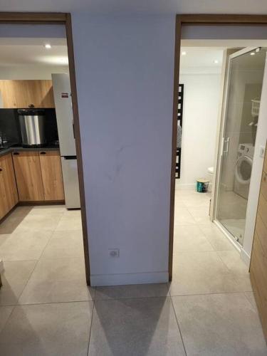 une cuisine avec une porte s'ouvrant sur une chambre dans l'établissement Studio 2 personnes équipé, à Vignac