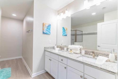 baño con 2 lavabos y espejo grande en Apartment at Vista Cay Resort, en Orlando