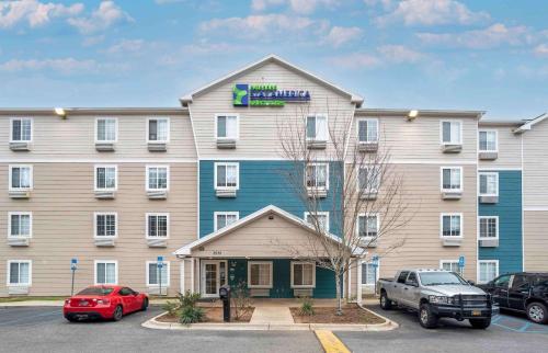 a large building with cars parked in a parking lot at Extended Stay America Select Suites - Tallahassee - East in Tallahassee
