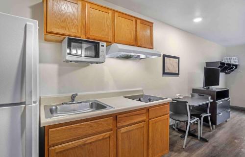a kitchen with a sink and a microwave at Extended Stay America Select Suites - Tallahassee - East in Tallahassee