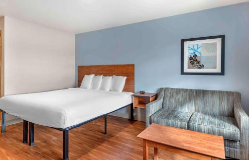 - une chambre avec un lit, une chaise et un canapé dans l'établissement Extended Stay America Select Suites - Wichita - North, à Wichita