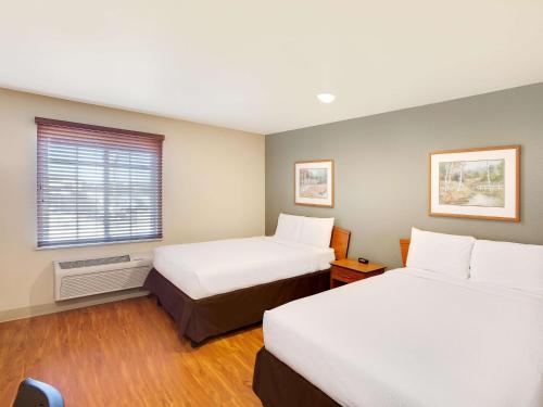 a hotel room with two beds and a window at Extended Stay America Select Suites - Shreveport - Bossier City in Bossier City