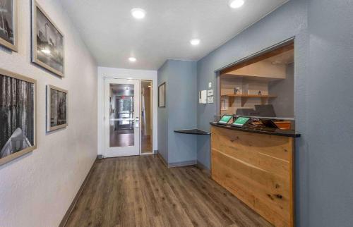 a room with a hallway with blue walls and wooden floors at Extended Stay America Select Suites - Shreveport - Airport in Shreveport