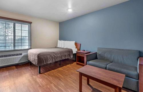 sala de estar con sofá y cama en Extended Stay America Select Suites - Shreveport - Airport, en Shreveport