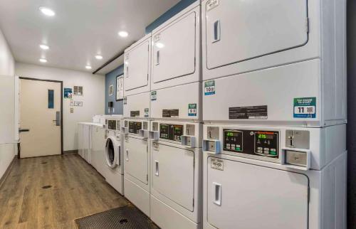 a laundry room with white cabinets and a washer and dryer at Extended Stay America Select Suites - Tallahassee - Northwest in Tallahassee