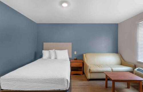 1 dormitorio con 1 cama, 1 sofá y 1 silla en Extended Stay America Select Suites - Springfield - South - Battlefield, en Springfield