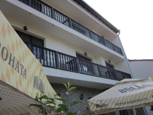 an apartment building with a balcony and an umbrella at Hotel Terazini in Veliko Tŭrnovo