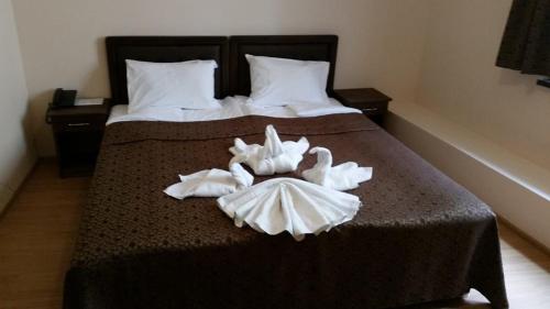 a hotel room with two swans towels on a bed at Hotel Terazini in Veliko Tŭrnovo