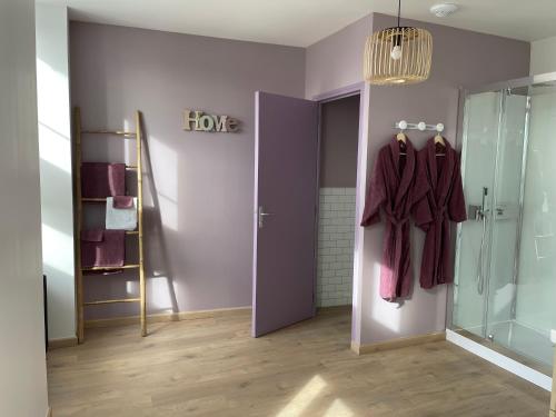 a bathroom with a shower and a door with a robe at La petite Irlande in Auderville