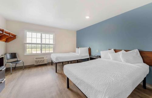 Del CityにあるExtended Stay America Select Suites - Oklahoma City - Del Cityのベッドルーム1室(ベッド2台、デスク、窓付)