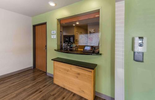 a room with green walls and a counter with a mirror at Extended Stay America Select Suites - Oklahoma City - Southeast in Moore
