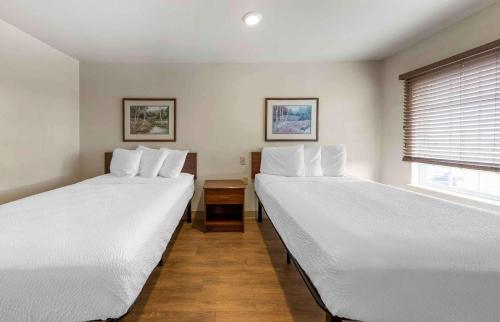 two beds in a room with a window at Extended Stay America Select Suites - Oklahoma City - Southeast in Moore