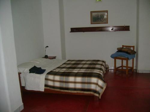 1 dormitorio con 1 cama con manta a cuadros en Los Faiques Ecolodge, en Salas
