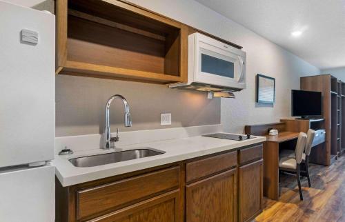 a kitchen with a sink and a microwave at Extended Stay America Suites - Tampa - Northeast in Tampa