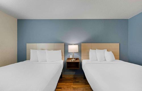 two beds in a room with blue walls at Extended Stay America Suites - Tampa - Northeast in Tampa